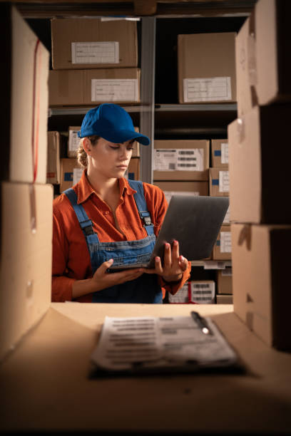 istock Inventory manager checks stock using laptop computer working in warehouse with rows of shelves 1683722199