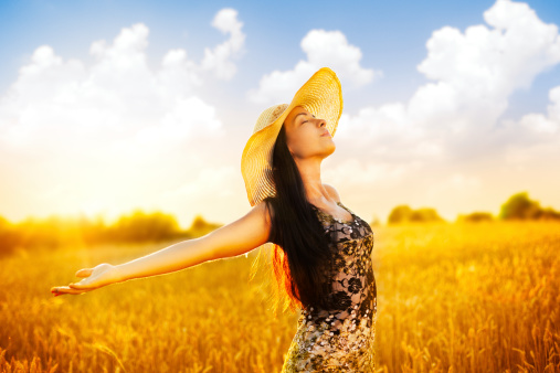 Beautiful Young Caucasian Woman walking through wheat field