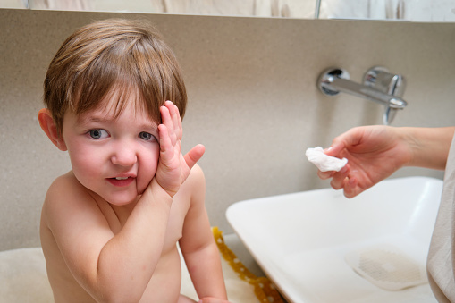 The child refuses to wash by closing his hand. Kid aged two years (two-year-old boy) Baby doesn't want to wash in the bathroom