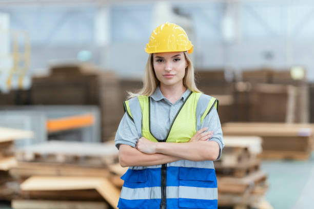 istock Female employee looking at camera while operating machinery in warehouse 1683770837