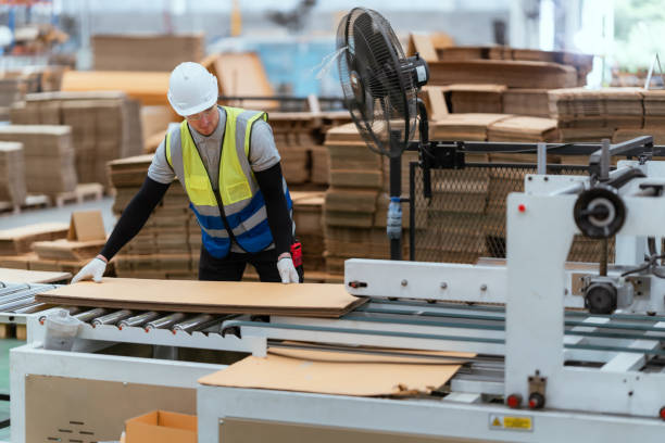 istock A male employee is using a machine to sew cardboard boxes in a warehouse. and arrange cardboard boxes 1683774093