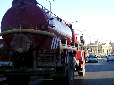 Cairo, Egypt, September 10 2023: Tanker truck with a container tank with liquid products, a lorry on the highway with a container on it delivering the products for industrial usage, selective focus