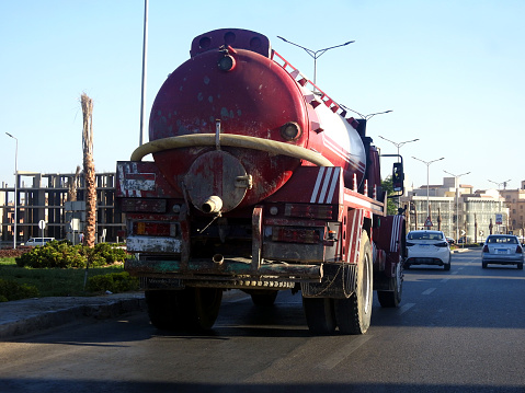 Cairo, Egypt, September 10 2023: Tanker truck with a container tank with liquid products, a lorry on the highway with a container on it delivering the products for industrial usage, selective focus