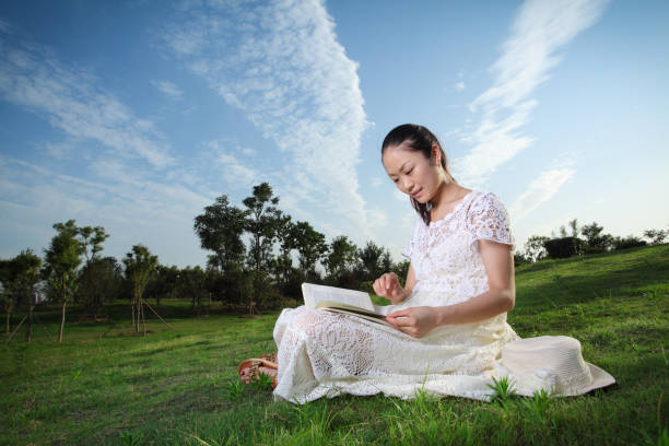 istock Young woman reading on the lawn 168381860