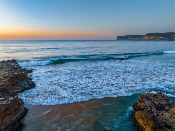 istock Sunrise over the ocean and rock platform with clear skies 1683820754