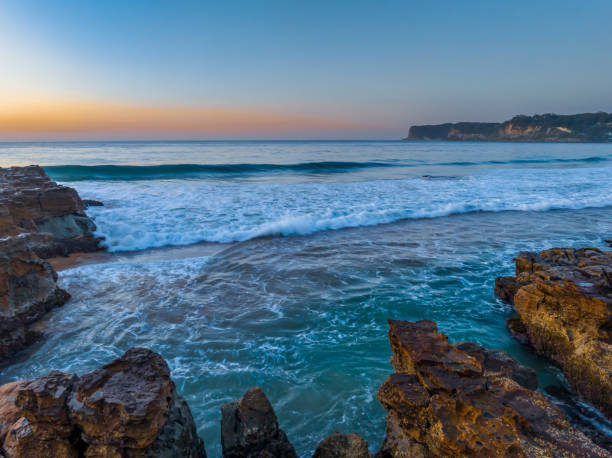 istock Sunrise over the ocean and rock platform with clear skies 1683822499