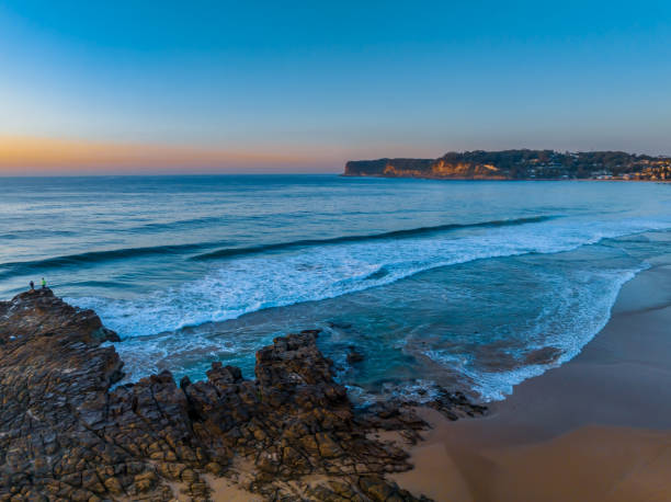 Sunrise over the ocean and rock platform with clear skies