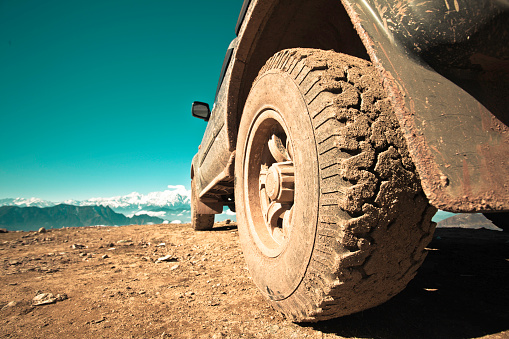 4x4 car parked on dirt road among the mountain and meadow on sunny day in summer at Iceland