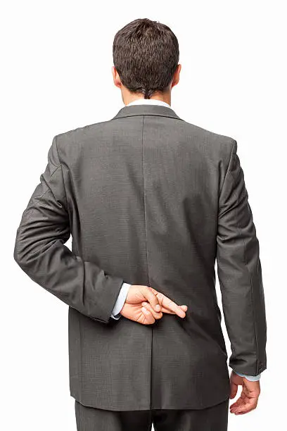 Rear view of a businessman crosses his fingers behind his back. Vertical shot. Isolated on white.