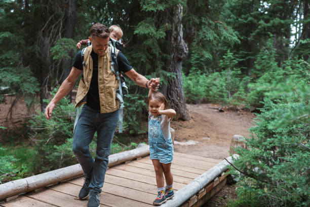 istock Loving father helps daughter walk across log bridge 1683860721