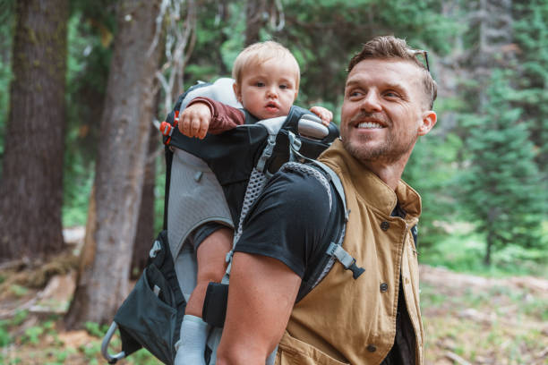 istock Young man smiles at baby son while hiking 1683860724
