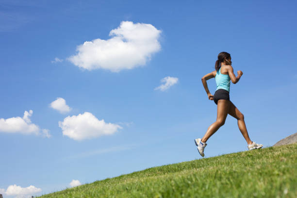istock A female running outdoors on green grass 168389120