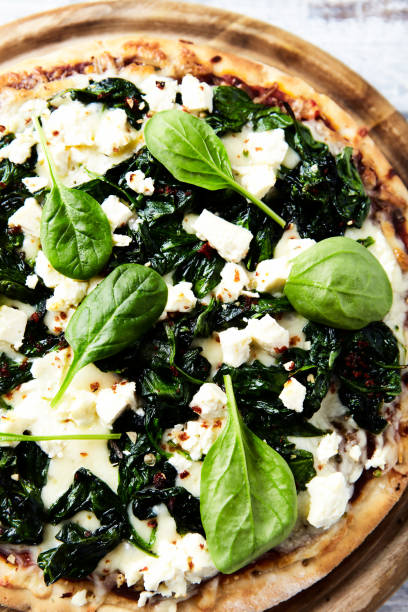 istock Pizza with mozzarella cheese, spinach and fresh basil. Soft focus. Top view. Close up. 1683916031