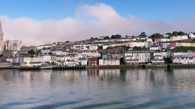Sunny day over Cobh panorama, a view from the water with row of houses, blue sky, cathedral. County Cork, Ireland