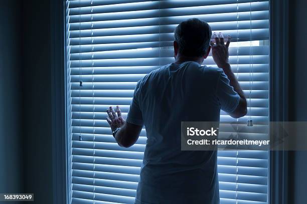 Homeowner Nervously Checks On Outside Noise Late At Night Stock Photo - Download Image Now