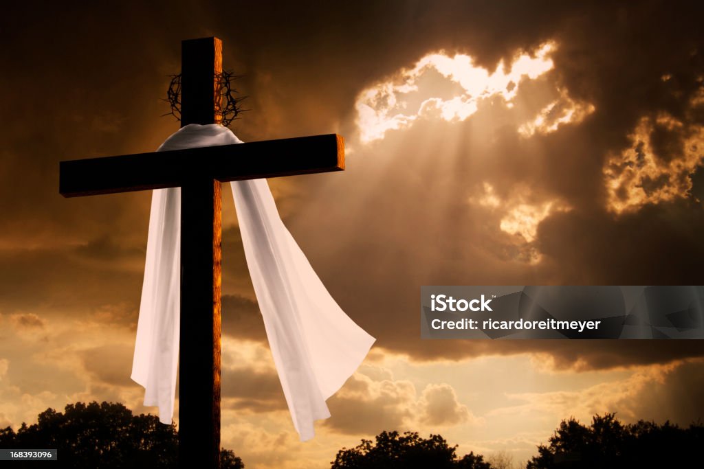 Dramatic Lighting on Christian Easter Cross As Storm Clouds Break This dramatic lighting with storm clouds breaking and sunshine bursting through makes a great Easter photo illustration of Jesus dying on the cross and rising again. Easter Stock Photo
