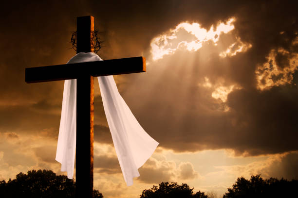 Dramatic Lighting on Christian Easter Cross As Storm Clouds Break stock photo