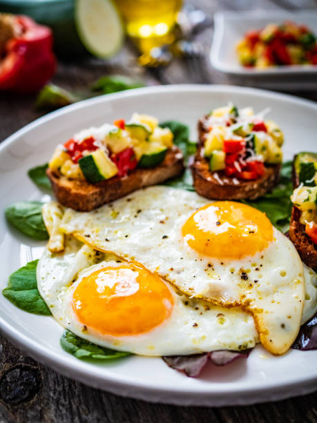 istock Continental breakfast -   fried eggs and bruschetta with fresh vegetables on wooden table 1683943713
