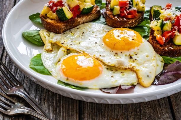 istock Continental breakfast -   fried eggs and bruschetta with fresh vegetables on wooden table 1683944744