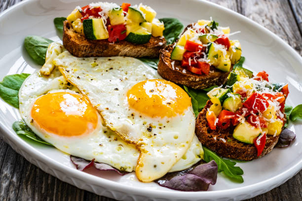 istock Continental breakfast -   fried eggs and bruschetta with fresh vegetables on wooden table 1683945254