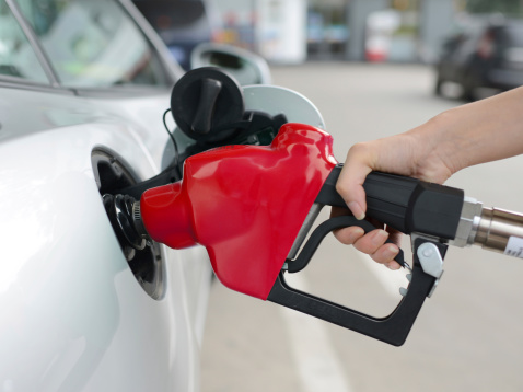 Man holds a refueling gun in his hand for refueling cars. Gas station with diesel and gasoline fuel close-up