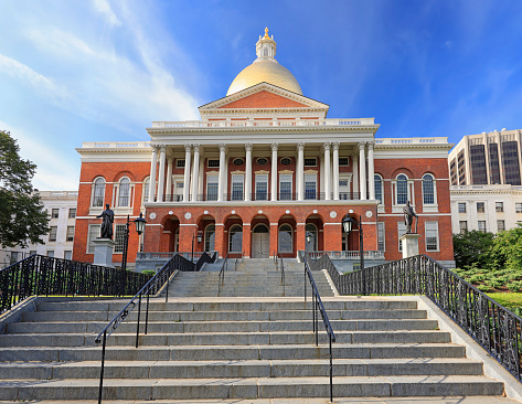 Massachusetts State House and State Library, USA. Imposing red building with white columns and golden dome