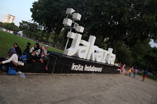 Lapangan Banteng Park, Jakarta, Indonesia - June 18, 2023: The evening atmosphere of people relaxing at the city's tourist attractions