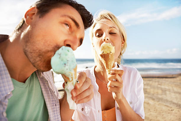 istock Young couple having an ice cream on the beach 168403327