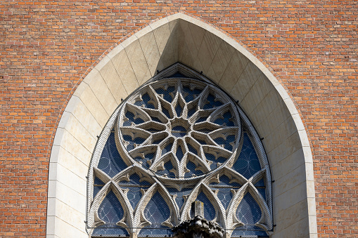 Krakow, Poland - September 6, 2023: Medieval Basilica of Holy Trinity Catholic church located at Stolarska Street in the Old. Rose window at facade