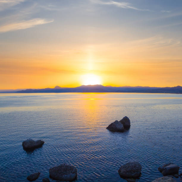 istock calm sea bay with stones at the sunset 1684081408