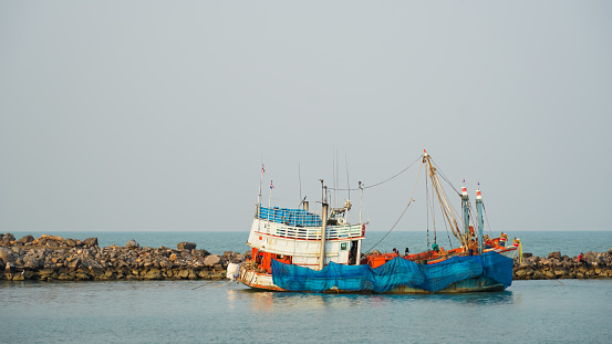 Small fishing boat sailing in the sea, close-up. Leisure activity, sport and recreation, food industry, traditional craft, environmental damage concepts