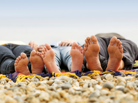 Family laying down on a rocky beach in Brighton, England