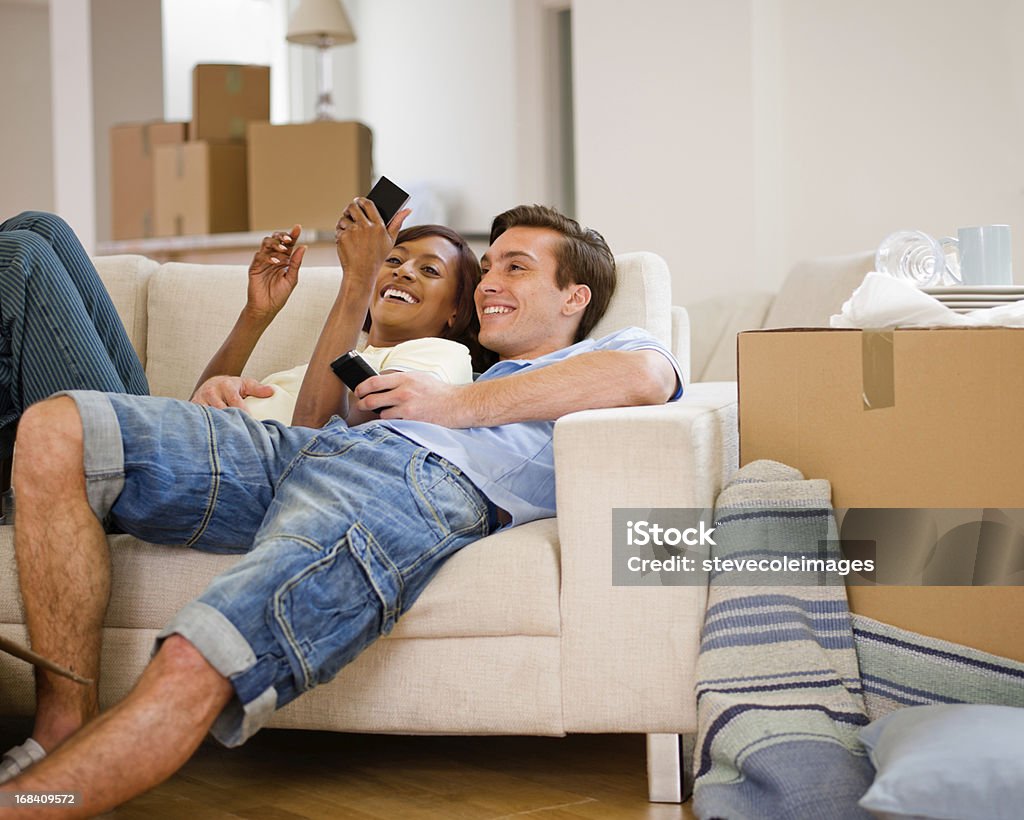 Etnico coppia Relax sul divano dopo lo spostamento - Foto stock royalty-free di Divano