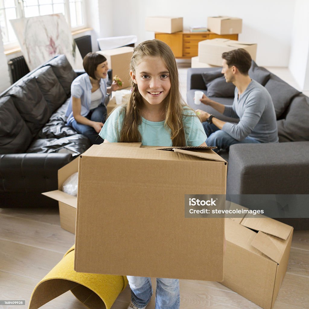 Family Moving A family relaxing after unpacking a few boxes in their new home. Relocation Stock Photo