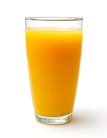 A glass of carrot juice on a dark wooden background. Flat lay.