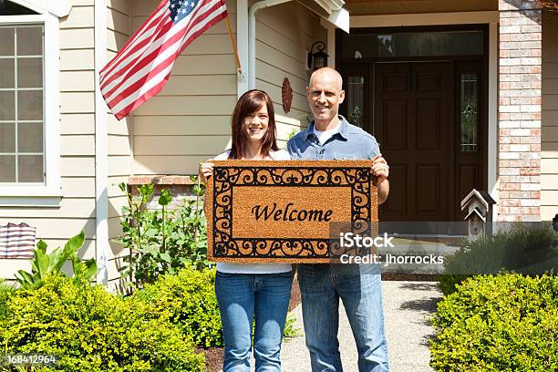 Photo libre de droit de American Couple À La Maison Avec Le Tapis De Bienvenue banque d'images et plus d'images libres de droit de Tenir