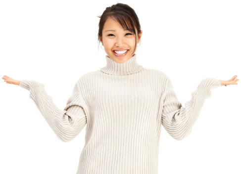 Photo of an attractive young Asian womain wearing a light gray sweater, shrugging with hands out; isolated on white.