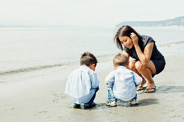 Mother and Curious Sons Crouching on Seattle Beach