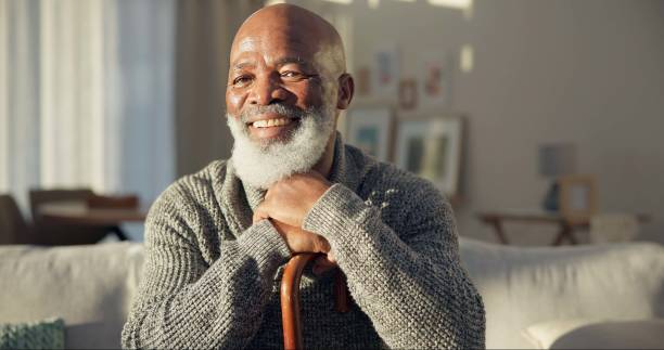 istock Happy, face and a black man with a cane on the sofa for support, medical help and retirement. Smile, house and portrait of a senior African person on the living room couch with a stick for walking 1684148971