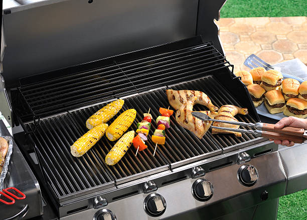 Backyard grilling scene with bbq kabobs, corn and chicken stock photo