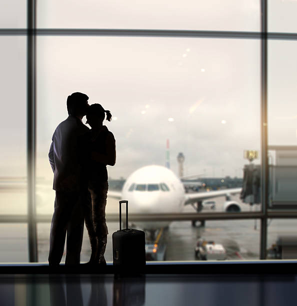 A couple hugging each other at the airport stock photo