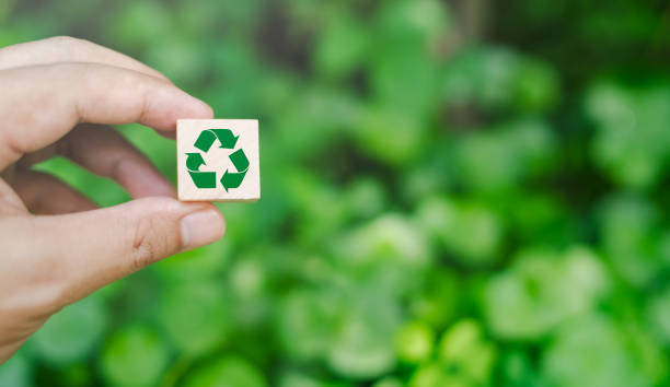 istock Hand holding a wooden cube with an environmentally friendly recycling icon. on a green background Concept of green business and sustainable development Earth Day. 1684180566