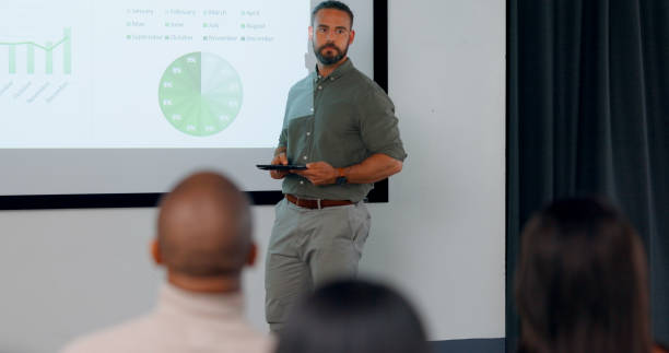 istock Presentation, business man and hands for question in audience during training workshop and finance talk. Speaker, coach or leader for knowledge, budget or growth analysis meeting on screen for faq 1684183732