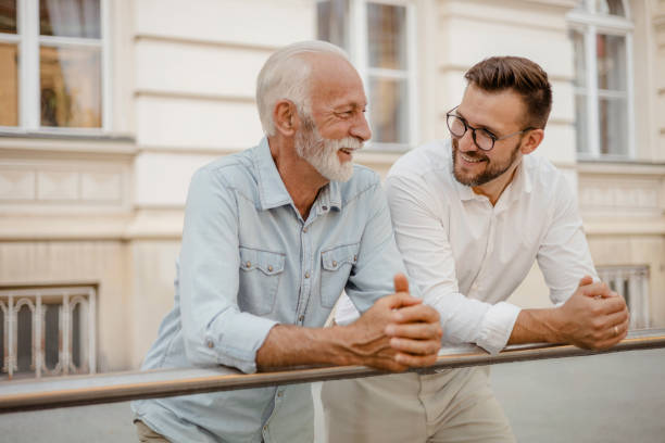 Happy Senior Father and Adult Son Chatting Bonding Photo of Happy Senior Father and Adult Son Chatting Bonding Relaxing Having Friendly Positive Conversation father son grandfather fathers day stock pictures, royalty-free photos & images