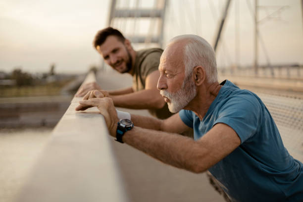 Senior Father and His Adult Son Doing Exercise and Workout Senior Father and Adult Son Doing Exercise. Having Fun Together father son grandfather fathers day stock pictures, royalty-free photos & images