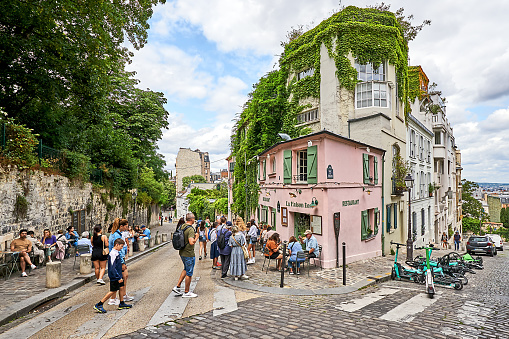 Paris, France - October 9, 2014:   Charming street scene with a couple dining outside a French Bistro in the Latin Quarter.  The Latin Quarter in Paris's left bank is a notable and well visited district known for it's quaint streets, shops and dining. 