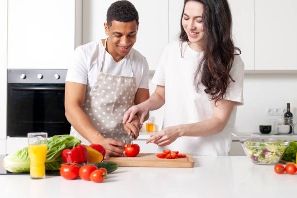 istock multiracial young couple preparing veggie vegetable and greens salad in white modern kitchen 1684247446