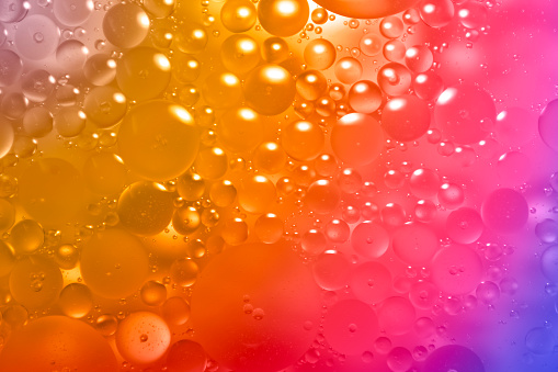 Abstract background image of oil drops on the water surface in various shades giving a fresh, rounded, and beautiful sparkling feeling.