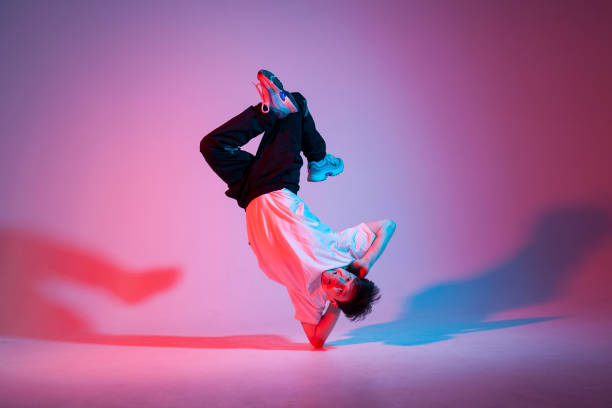 istock young guy dancer is dancing break in neon lighting, male acrobat is doing trick and dance exercise 1684255160