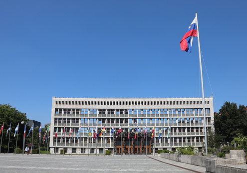 Ljubljana, L, Slovenia - August 16, 2023: Parliament building of the European Capital and big Flag